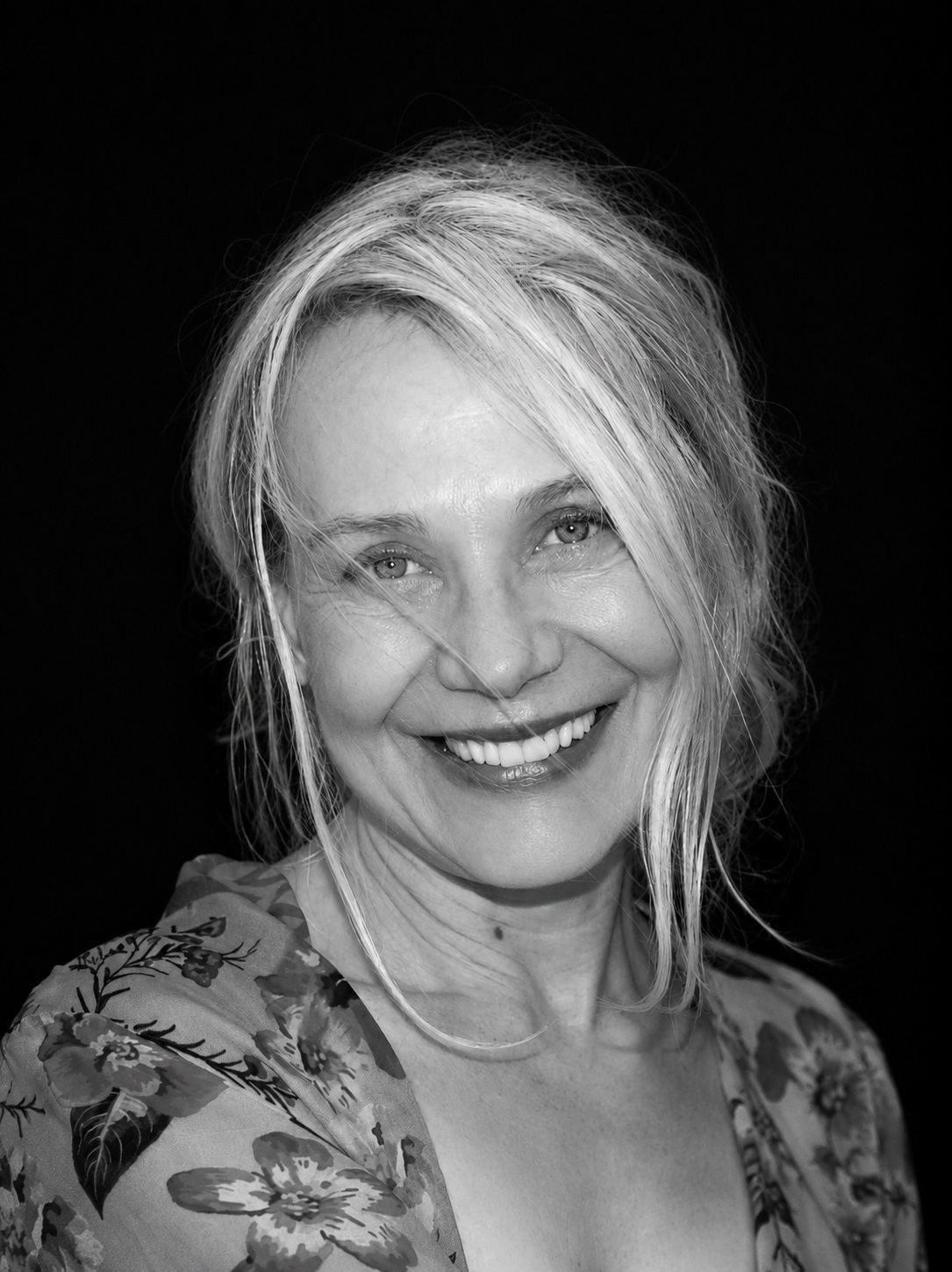 Black-and-white portrait of Dr Karien Earle, smiling, against a dark background